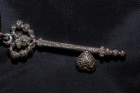 Silver pendant heart shaped key, made with pink crystal stones macro.