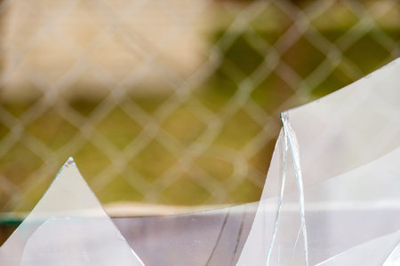 Sharp glass hole cracks splinters, broken glass by the street.の写真素材