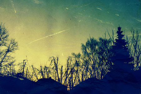 Landscape of silhouetted trees and houses with crescent moon and morning sky, grunge paper textured.の写真素材