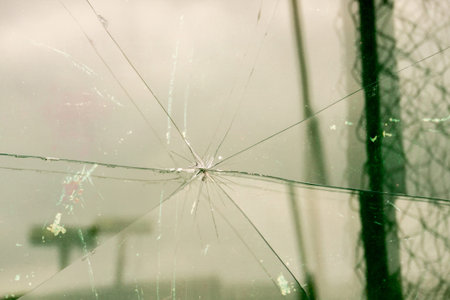 Sharp glass hole cracks splinters, broken glass by the street.