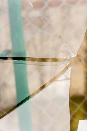 Sharp glass hole cracks splinters, broken glass by the street.の写真素材