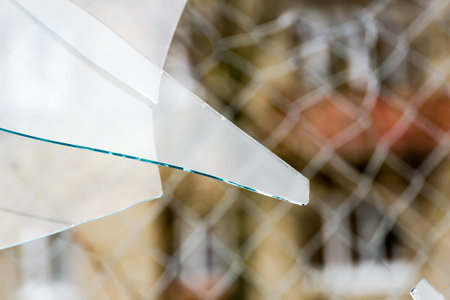 Sharp glass hole cracks splinters, broken glass by the street.