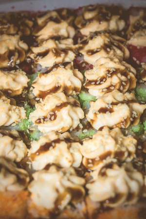 Set of sushi rolls with cream cheese and caramel sauce, vintage macro.の写真素材