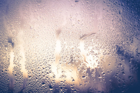 Wet glass with drops of rain, close up background.