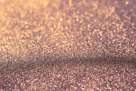 Decorative brown glitter texture macro, defocused background, bokeh.
