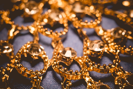 Elegant golden necklace with jewel stones on a background of blue silk, vintage background.の写真素材