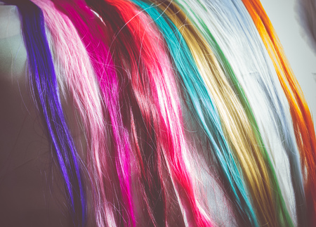 Synthetic hair extensions of different colors close up background.の写真素材