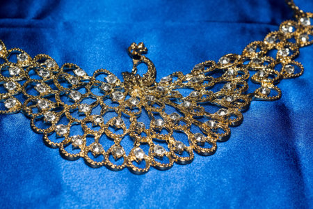 Elegant golden necklace with jewel stones on a background of blue silk.の写真素材
