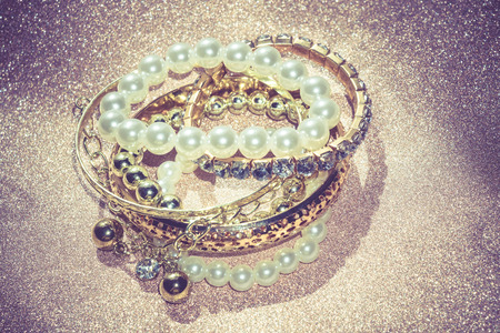 Stylish fashion bracelets with acrylic beads, pearls on vintage glittering background.の写真素材