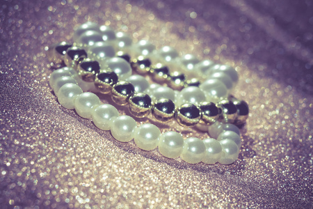 Stylish fashion bracelets with acrylic beads, pearls on vintage glittering background.の写真素材