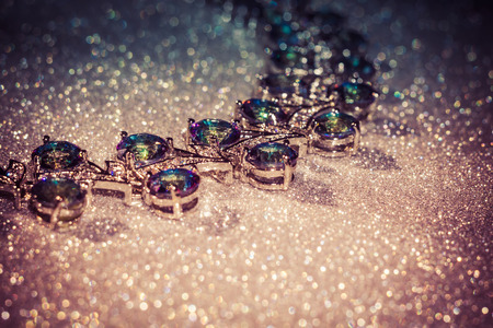 Fashion bracelet with mystic topaz, rainbow topaz on filtered glittering background.の写真素材