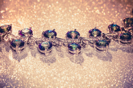 Fashion bracelet with mystic topaz, rainbow topaz on filtered glittering background.の写真素材