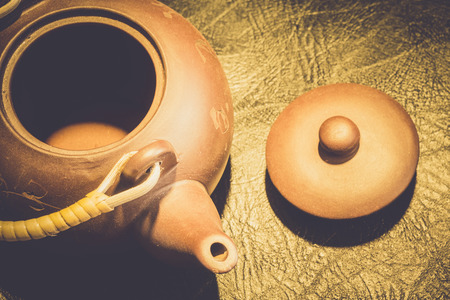 Brown chinese clay teapot close up on black leather background.の写真素材