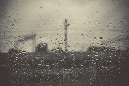 Drops of rain on a grunge window glass, filtered background.