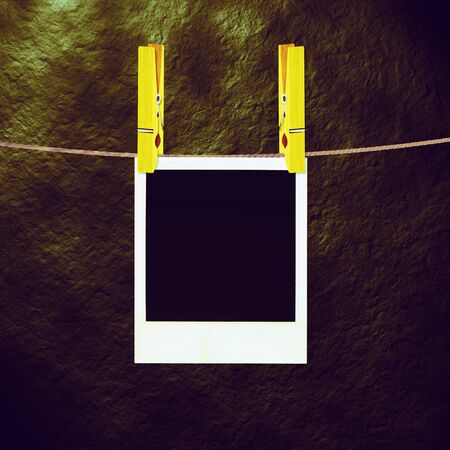 Old photo film blanks hanging on a rope held by clothespins.の写真素材