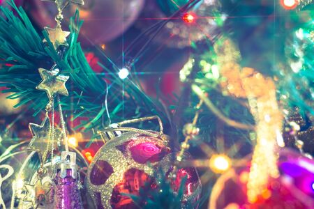 Close up of Christmas or New Year fir tree with decorative lights and toys, filtered background.の写真素材