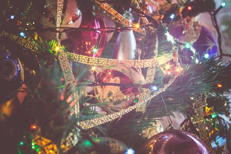 Close up of Christmas or New Year fir tree with decorative lights and toys, filtered background.の写真素材