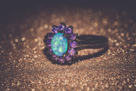 Fashion ring decorated with blue fire opal stones, filtered background.の写真素材