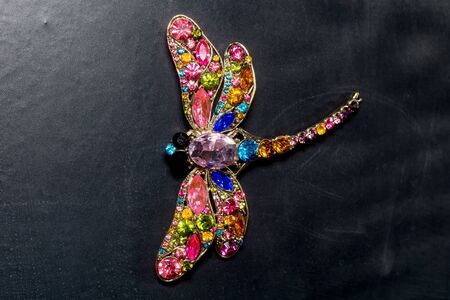 Brooch in a shape of a dragonfly decorated with multicolored rhinestones, fashion jewellery.の写真素材