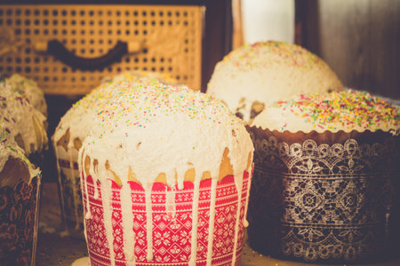 Tasty Easter bread with colorful decorations on white cream.