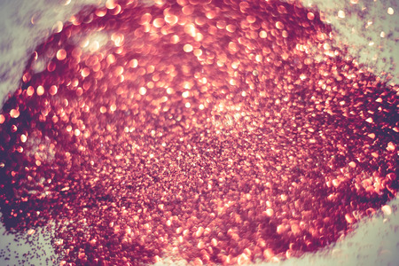 Defocused glitter as filtered background with circular bokeh of red color.の写真素材