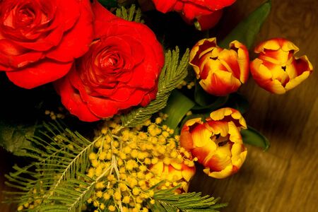 Bouquet with bright red roses and decorative tulips over silk background.の写真素材