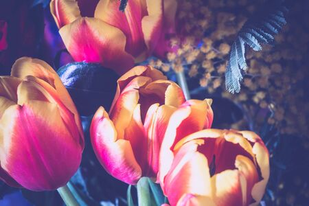 Bouquet with bright red roses and decorative tulips over silk, filtered background.の写真素材