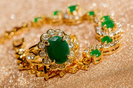Elegant female jewelry golden ring with precious green gem, emerald.の写真素材
