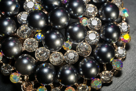 Decorative fashion round brooch with black pearls and rhinestones.