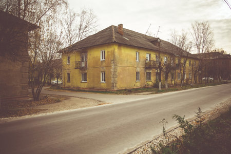 Old plastered yellow house near street roadの写真素材