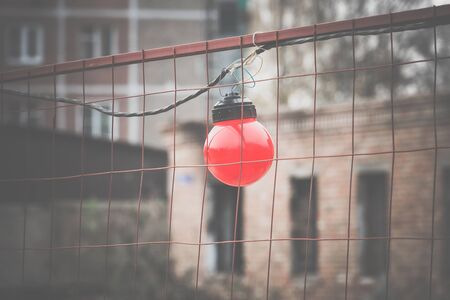 Round red warning lights on the metal mesh fence, construction site, vintage background.の写真素材