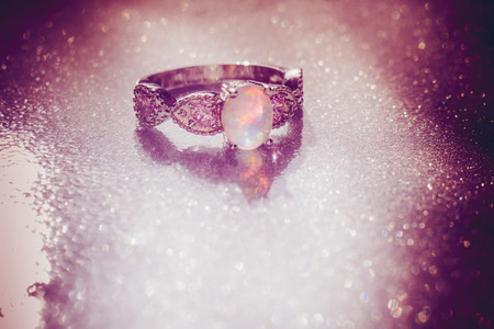 Fashion ring decorated with white fire opal stones, filtered background.の写真素材
