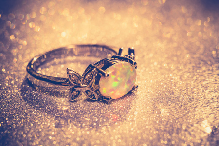 Fashion ring decorated with white fire opal stones, filtered background.の写真素材