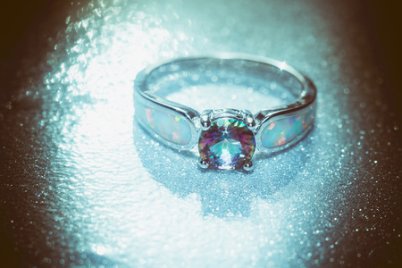 Fashion ring with mystic topaz, rainbow topaz, modern jewelry, filtered background.の写真素材