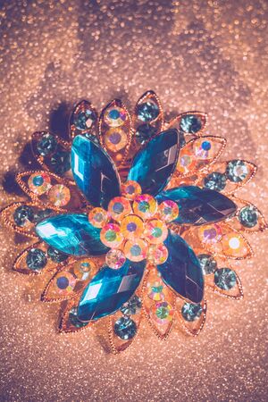 Decorative fashion flower shaped brooch with blue stones, vintage background.の写真素材