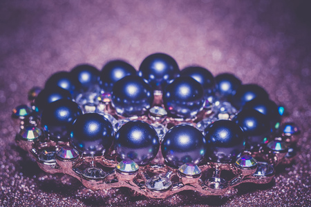 Decorative fashion round brooch with black pearls and rhinestones, filtered background.の写真素材