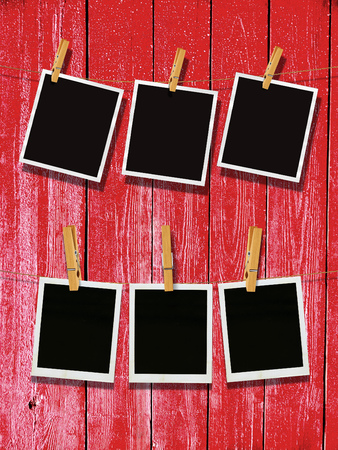 Old photo film blanks hanging on a rope held by clothespins over wooden background.の写真素材