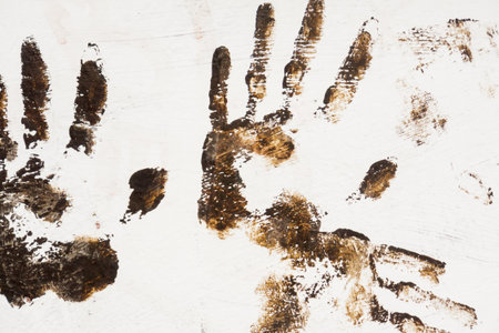 Grunge brown handprint on white painted rectangle surface.の写真素材