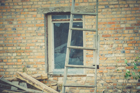 Old crumbling brick house, windows in ruined abandoned building filtered background.の写真素材