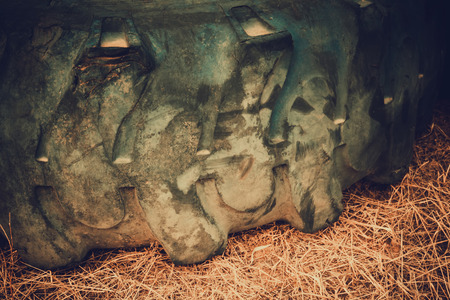 Big black rubber wheel laying on the sand, filtered background.の写真素材