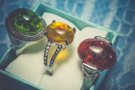 Vintage silver plated jewelry with colorful synthetic amber, filtered background.の写真素材