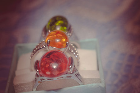 Vintage silver plated jewelry with colorful synthetic amber, filtered background.の写真素材