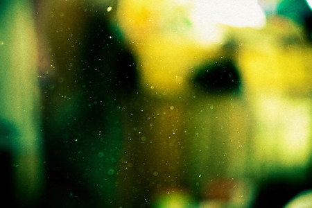 Defocused dust particles against sun, filtered shimmering bokeh effect.の写真素材