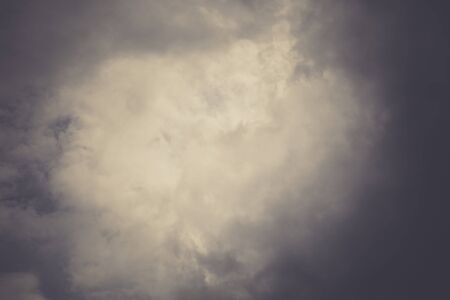 Dark sky with heavy stormy clouds, filtered natural background.の写真素材