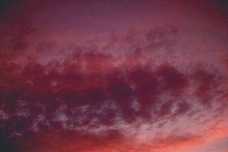 Summer sunset sky with clouds of red color, filtered background.の写真素材