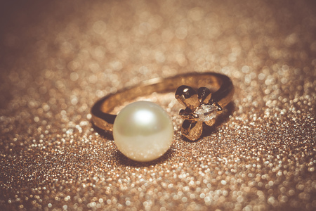 Luxury rose gold plated ring with freshwater pearl of white color, filtered background.の写真素材