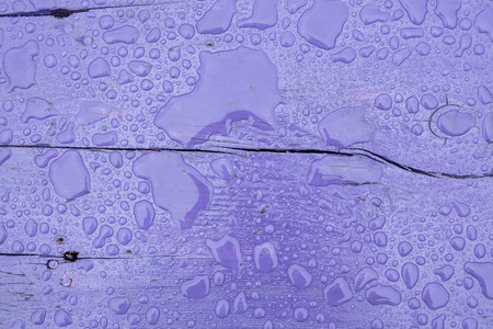 Wooden surface of violet color covered with water drops background.の写真素材