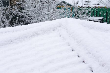 Red house roof covered with snow in snowfall.の写真素材