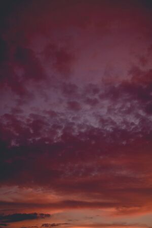 Summer sunset sky with clouds of red color, filtered background.の写真素材