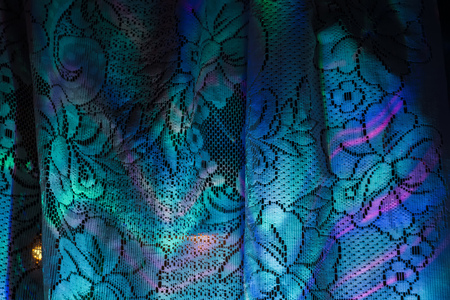 Defocused colorful garland lights reflection on white curtains background.の写真素材